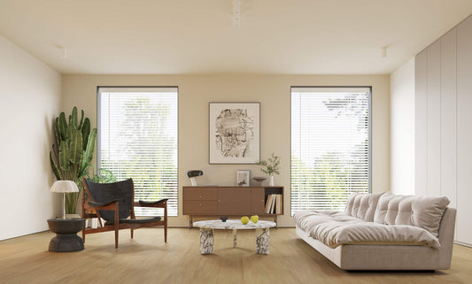 Modern living room with natural light, light hardwood flooring, neutral furniture, and large windows