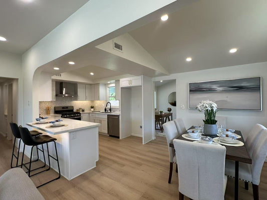 Modern kitchen and dining area with light hardwood flooring and elegant décor