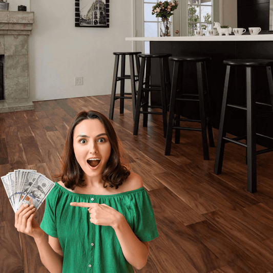 Surprised woman holding cash on hardwood flooring in modern kitchen setting