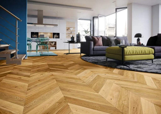 Chevron pattern hardwood flooring in a modern living room with open kitchen layout