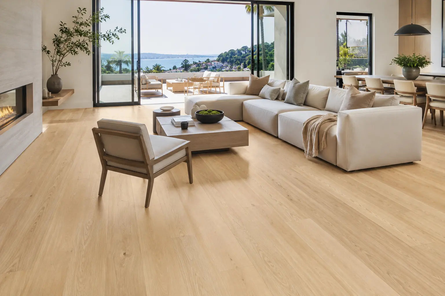 Modern kitchen with natural hardwood flooring and wood cabinets in bright, sunlit room